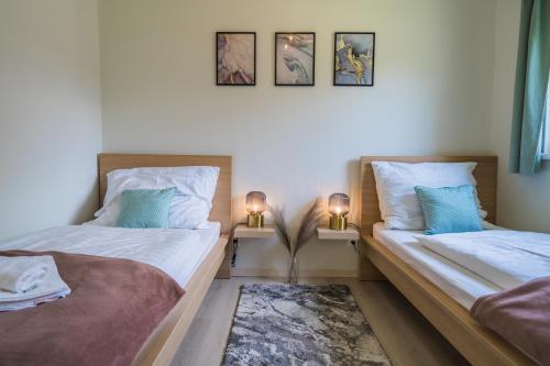 two twin beds in a room with two lamps at MyFlat Diana Family Apartment in Siófok