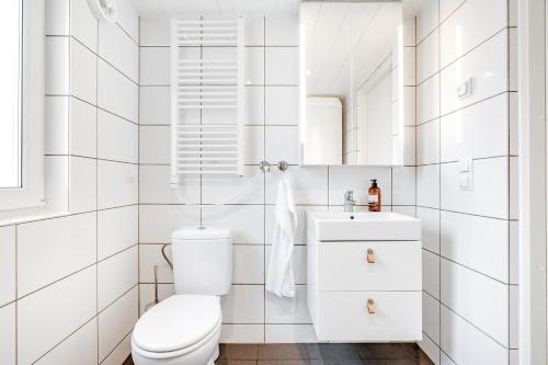 a white bathroom with a toilet and a sink at Minivilla by the sea in Dragsfjärd