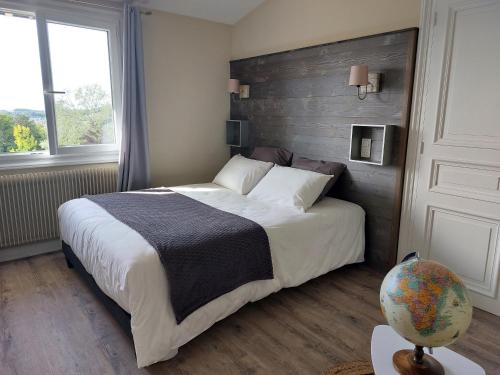 sypialnia z dużym łóżkiem z drewnianym zagłówkiem w obiekcie Le relais globe trotteur w mieście Montaigu