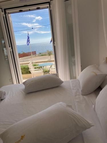 a white bed with a view of the ocean at Studios Angeliki in Lassi