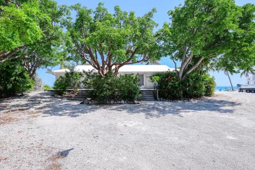 a white house on the beach with trees at The Zane Grey in Layton