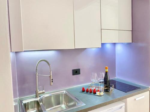 Una encimera de cocina con copas de vino y un fregadero. en Palace Fontana Di Trevi Prestige, en Roma