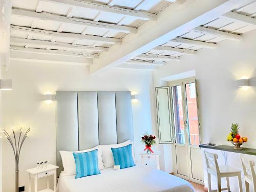 Un dormitorio con una cama blanca con almohadas azules. en Palace Fontana Di Trevi Prestige, en Roma