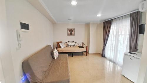 a living room with a couch and a bed at Seaflows Apartments #1 in Paralia Katerinis