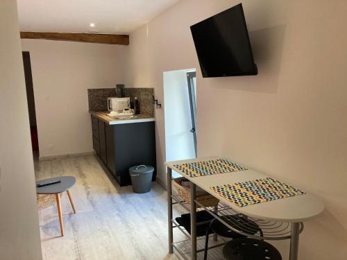 a small room with a table and a kitchen at Bel Air 1 in Fougeré