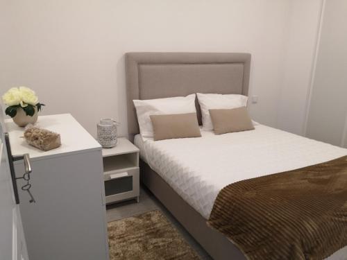 a bedroom with a bed and a vase of flowers at Casinha D'Avó in Nazaré