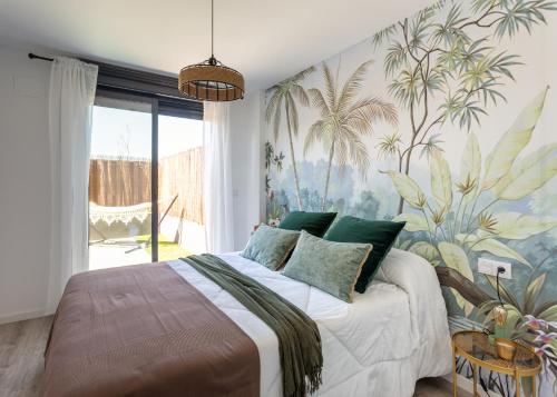 a bedroom with a large bed with a tropical wallpaper at Villamarco Beach Home at Playa San Juan - Muchavista in Alicante
