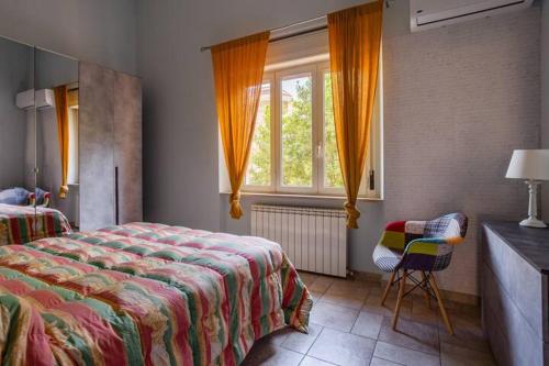 a bedroom with a bed and a window and a chair at Appartamento Fronte Mare - parcheggio privato in Pescara