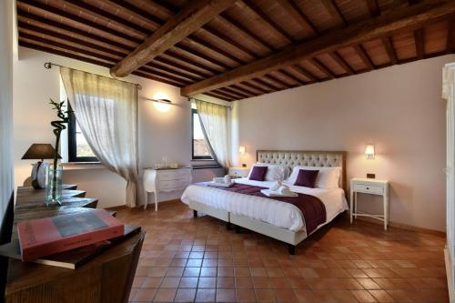 een slaapkamer met een bed, een bureau en ramen bij Porsenna Resort in Villastrada