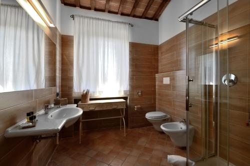 a bathroom with a sink and a toilet and a shower at Porsenna Resort in Villastrada