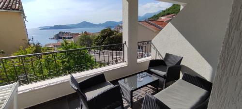 a balcony with chairs and a view of the ocean at Zoran Apartments in Sveti Stefan