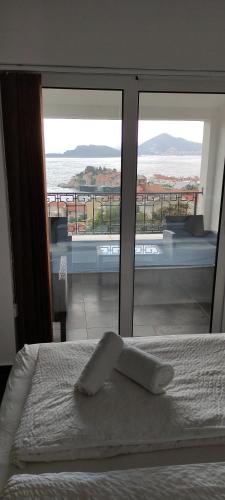 a bedroom with a bed with a view of the ocean at Zoran Apartments in Sveti Stefan