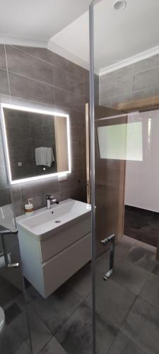 a bathroom with a white sink and a mirror at Zoran Apartments in Sveti Stefan