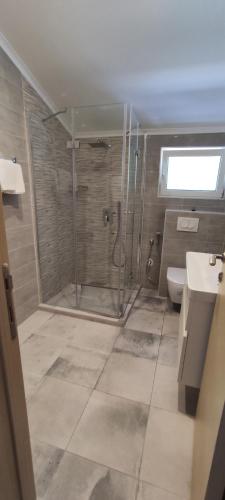 a bathroom with a shower and a toilet at Zoran Apartments in Sveti Stefan