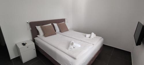 ein Schlafzimmer mit einem Bett mit zwei Handtüchern darauf in der Unterkunft Zoran Apartments in Sveti Stefan