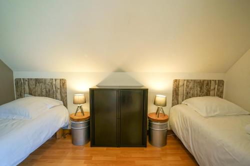 a bedroom with two beds and two lamps on the wall at Les Aravis - Apartment for 6 people 5min from the lake in Giez
