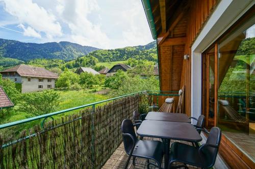 uma mesa e cadeiras numa varanda com vista em Les Aravis - Apartment for 6 people 5min from the lake em Giez