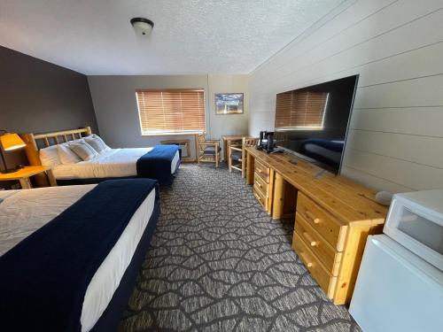 a hotel room with two beds and a flat screen tv at Teton Peaks Resort in Tetonia