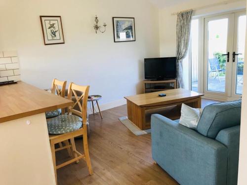 a living room with a blue couch and a table at Little welham in Bedale