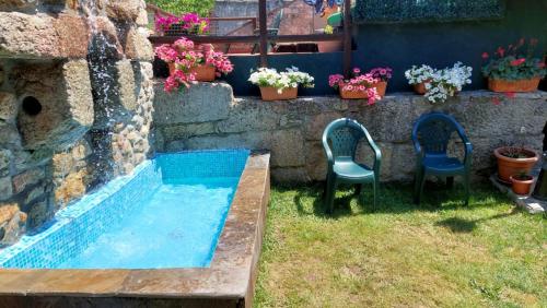 a backyard with two chairs and a swimming pool at Casa de pueblo en Galicia, A Forneira in Leiro