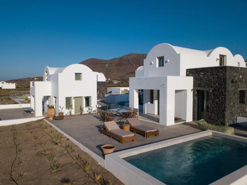 a house with a swimming pool in front of it at Oia Kissiri - private pool villas in Oia