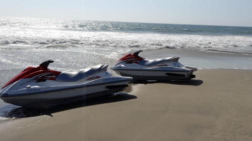 Dos lanchas rápidas sentadas en la arena de la playa en Origenes Spa & Lodging, en Vichayito