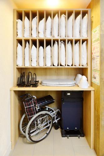 a bike sitting underneath a shelf with white dishes at Hotel La Foresta By Rigna in Fukuoka