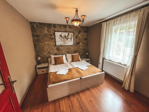 um quarto com uma cama grande e uma parede de pedra em Villa Emausy em Luhačovice