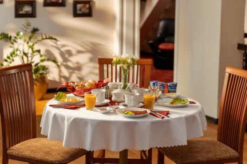 een witte tafel met eten en drinken erop bij Villa Toscania-check in 24h in Poznań