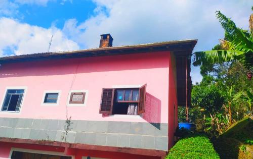 a red and white house with a window at POUSADA DO BAR- BUDO in Visconde De Maua