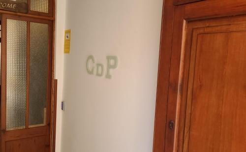 a white wall with a sign on it next to a door at Casal de Petra - Rooms & Pool by My Rooms Hotels TI in Petra