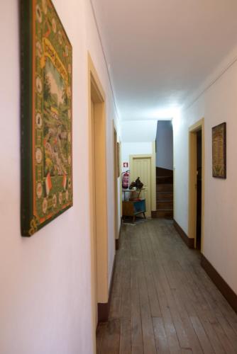 a hallway with a painting on the wall and a rug at Hospedagem Dona Rosalina in Seia