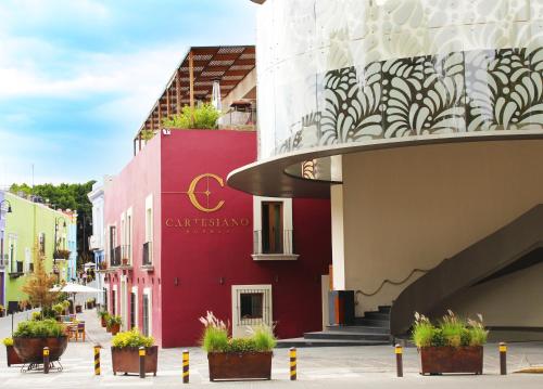 a building in a city with potted plants at Cartesiano Boutique & Wellness Hotel in Puebla