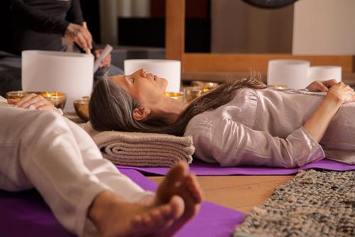 a woman laying on the floor in a yoga class at Cartesiano Boutique & Wellness Hotel in Puebla