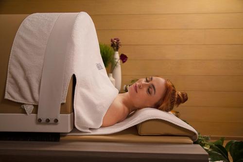 a woman laying on a towel next to a sewing machine at Cartesiano Boutique & Wellness Hotel in Puebla