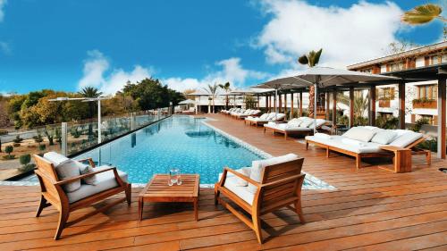 a swimming pool with lounge chairs and an umbrella at Cartesiano Boutique & Wellness Hotel in Puebla