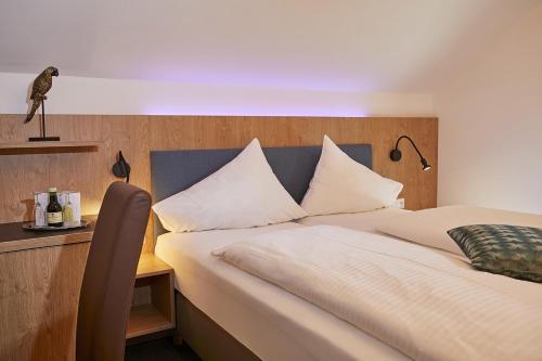 a bedroom with a large white bed with a wooden headboard at Dei Hotel Schönblick in Velden am Wörthersee