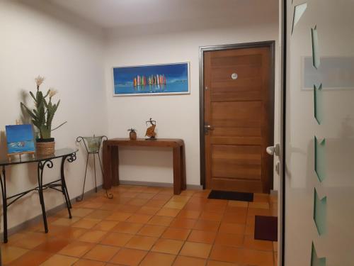 - un couloir avec une porte, une table et un bureau dans l'établissement Domaine Choco Vanille, à Deshaies