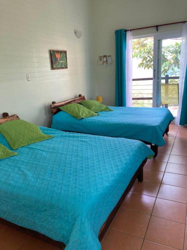 two beds in a room with a window at Rinconcito Verde in Ujarrás