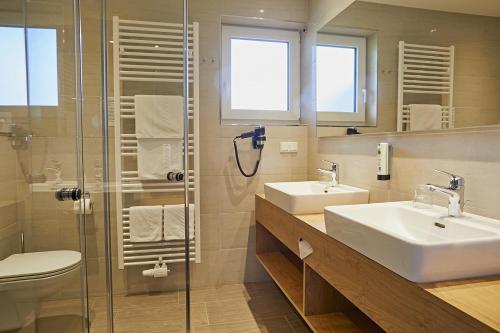 a bathroom with two sinks and a shower at Dei Hotel Schönblick in Velden am Wörthersee