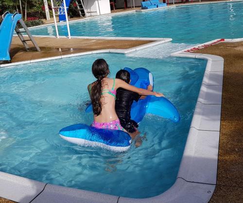 a young girl and a boy riding on an inflatable at Balneario Chorillano in Villavicencio