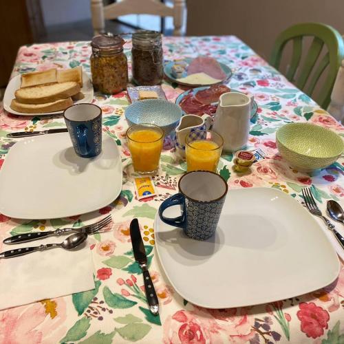 a table topped with plates and glasses of orange juice at L' Abilleiru Albergue Rural in Santibáñez de Valdeiglesias