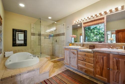 een badkamer met een bad, 2 wastafels en een douche bij Lejos in Wimberley