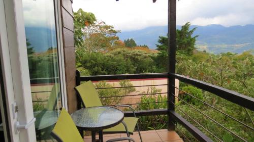 a balcony with a table and chairs and a view at Rinconcito Verde in Ujarrás