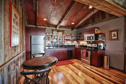 cocina con mesa y techo de madera en Luxury Cabins @Stony Ridge-Ruby, en Wimberley