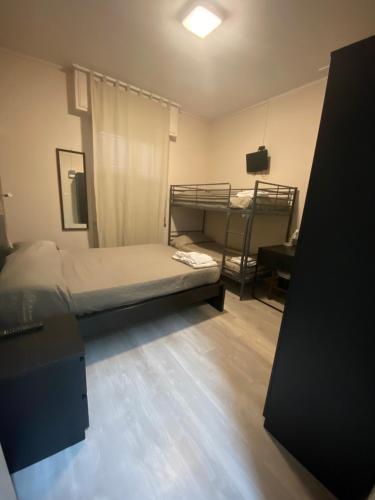 a bedroom with two bunk beds and a desk at Hotel La Pergola in Loano