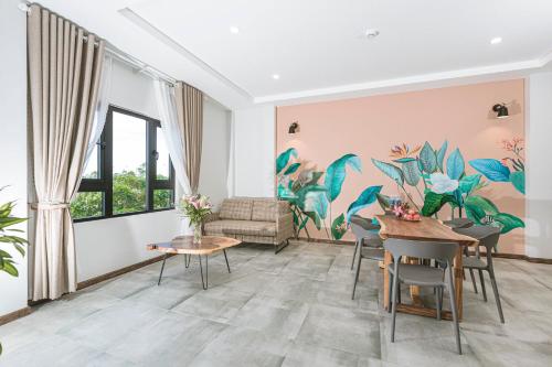 a dining room with a mural of plants on the wall at Tran Long Cu Hin Hotel - Near Bai Dai Beach in Cam Lâm