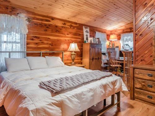 ein Schlafzimmer mit einem Bett in einem Zimmer mit Holzwänden in der Unterkunft Fly Away Cabin- Modern, Serene, And Convenient in Compton