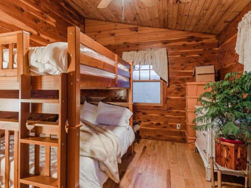 a bedroom with bunk beds in a log cabin at Fly Away Cabin- Modern, Serene, And Convenient in Compton