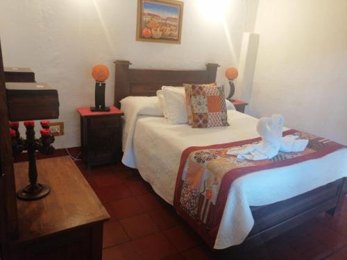 una camera da letto con un letto con un animale di peluche sopra di Hospedería Colonial de Villa de Leyva a Villa de Leyva